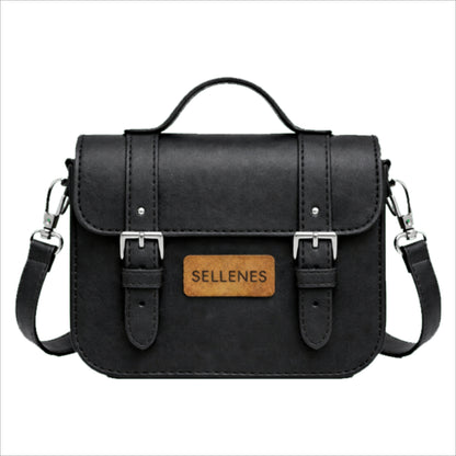 BirkBag by Sellenes structured bag features a top handle, a detachable leather shoulder strap with silver hardware, and two vertical straps with polished silver buckles on the front flap.