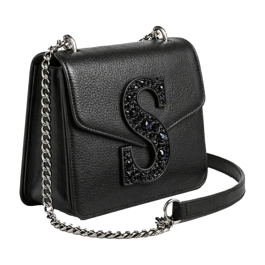 Sellenes Moon luxury black pebble-grain leather crossbody bag featuring a signature black stone-encrusted 'S' logo on the front flap. The designer handbag includes a silver-tone chain and leather shoulder strap.