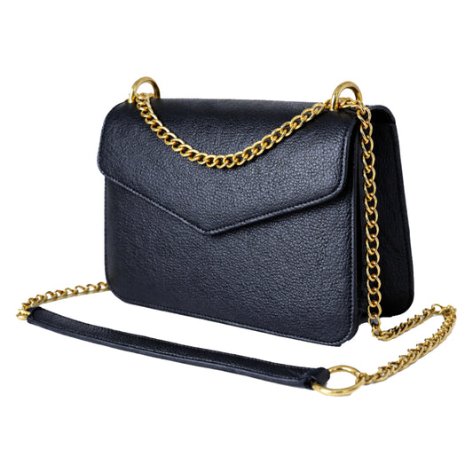 Sellenes MoonS black pebbled leather crossbody bag with a V-shaped envelope flap and gold chain strap featuring a leather shoulder pad, isolated on a white background.