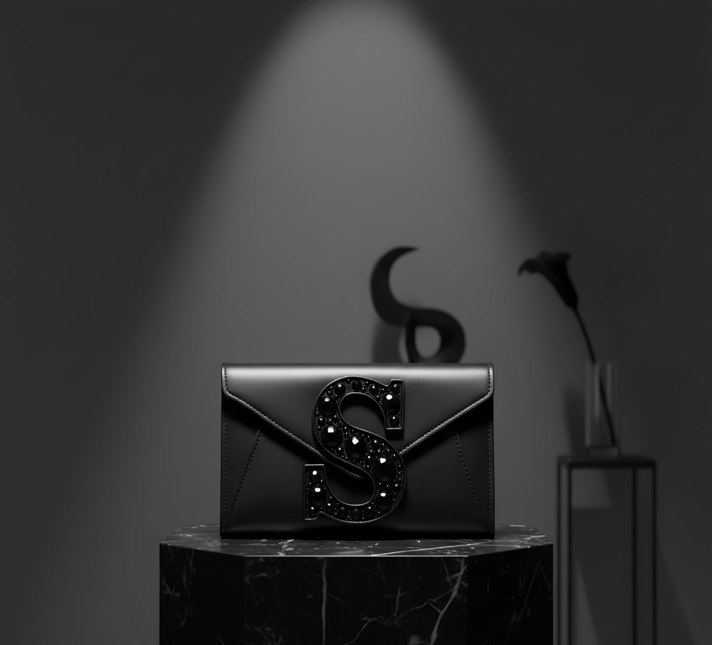 Valeya Black clutch with decorative 'S' on a dark background