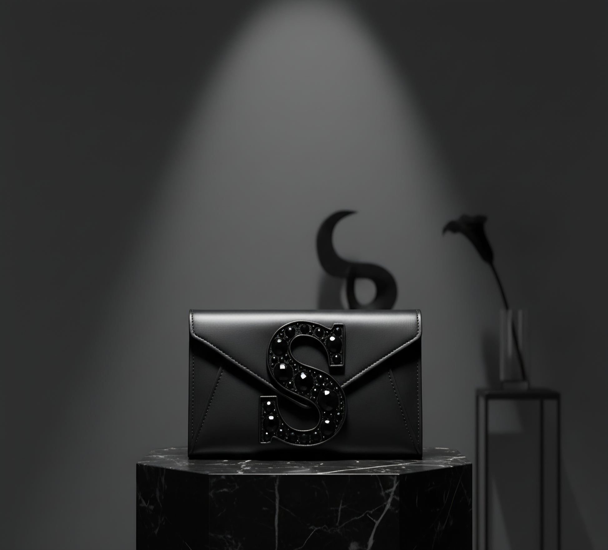 Valeya Black clutch with decorative 'S' on a dark background