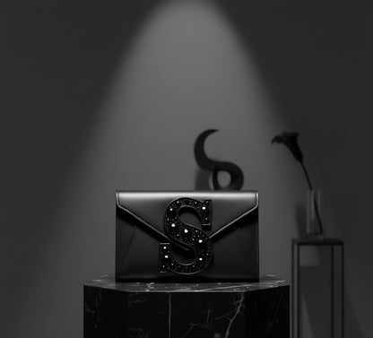 Valeya Black clutch with decorative 'S' on a dark background